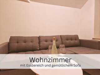 Wohnzimmer mit Sofa und gemütlichem Wipp-Sessel