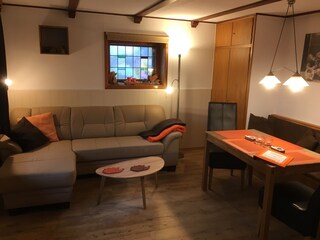 Wohnzimmer mit ausziehbarem Schlafsofa und Essecke