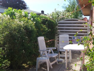 Südterrasse mit Gartenmöbel und Sonnenschirm.