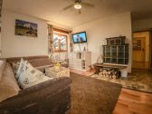 Living room with tiled stove and large sofa bed.