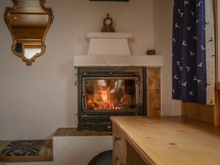 Gemütliche Wärme durch Holzofen im Schlafzimmer.