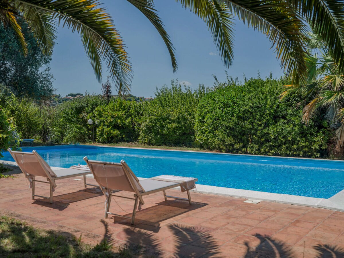 Villa Lucia – Pool mit Sonnenliegen und Sonnenschirm