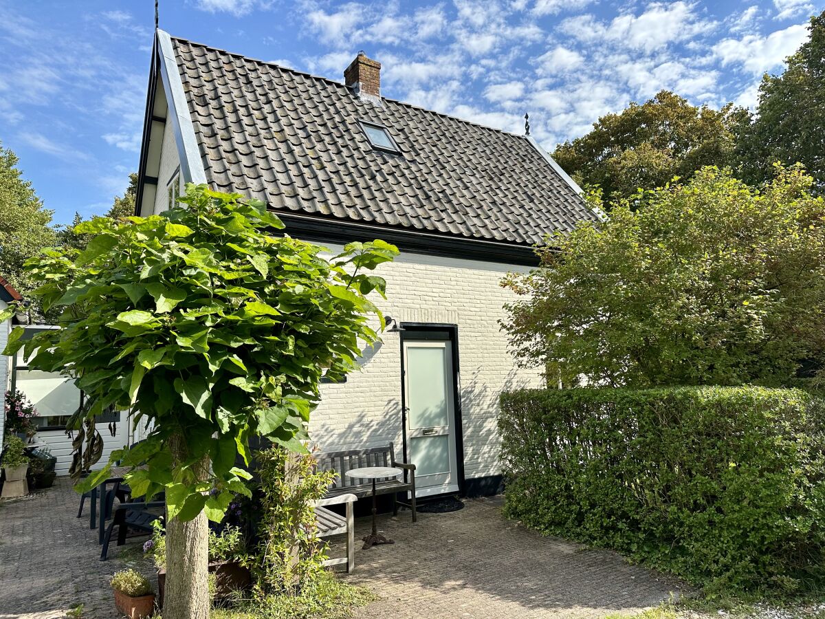 Ein charmantes Haus mit grünem Rasen und blauem Himmel.