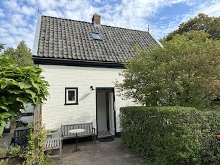 Ein charmantes Haus mit grünem Rasen und blauem Himmel.