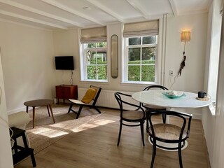 Gemütliches Wohnzimmer mit großen Fenstern.