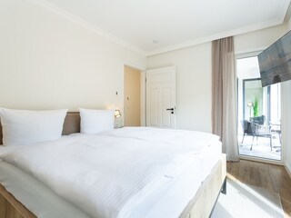 Schlafzimmer mit Kommode und TV