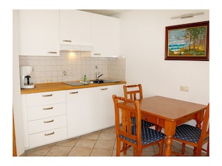 Küchenbereich mit Esstisch und 3 Stühlen