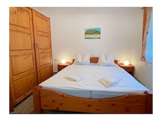 Schlafzimmer mit Doppelbett und Kleiderschrank