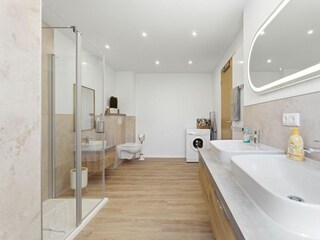 Badezimmer mit Dusche, Waschmaschine und WC im 1. OG