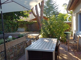 Terrasse mit Gartenmöbeln und Sonnenschirm