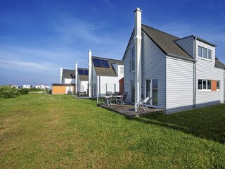Terrasse mit bequemen Gartenmöbeln, Essbereich im Freien mit Blick auf das Wasser