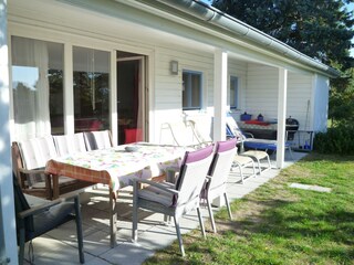 Überdachte Terrasse mit bequemen Gartenmöbeln