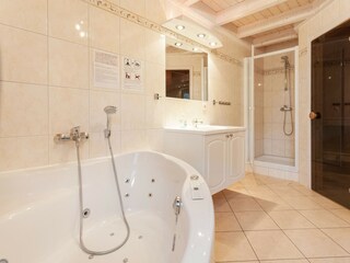 Das Badezimmer ist eine Wellnessoase mit Whirlpool und ....