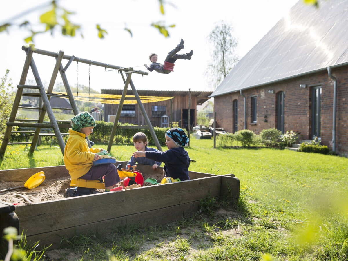 Rückseite mit Spielplatz und Garten