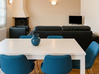 Wohnzimmer mit Kamin, Couch, Essplatz und Internet-TV