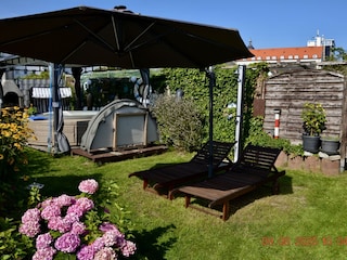 Liegewiese mit Sonnenschirm und Außendusche