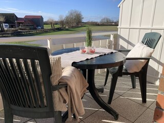 Der große Balkon ist mit Gartenmöbeln ausgestattet.