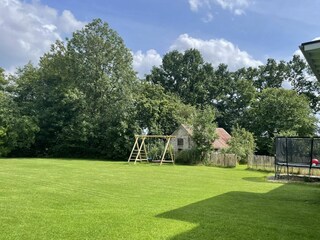 Garten mit Schaukel, Klettergerüst und Trampolin