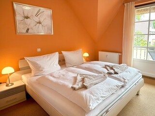 Schlafzimmer mit Kleiderschrank und Zugan zum Balkon