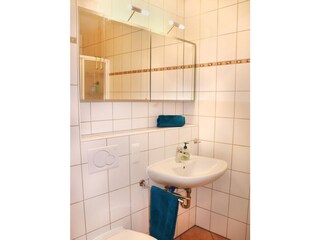 Badezimmer mit Dusche, Waschbecken, WC und Waschmaschine