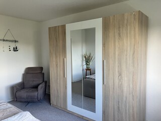 Kleiderschrank und Relaxsessel im 1. Schlafzimmer