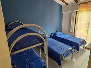 Schlafzimmer mit 2 Einzelbetten und 1 Etagenbett