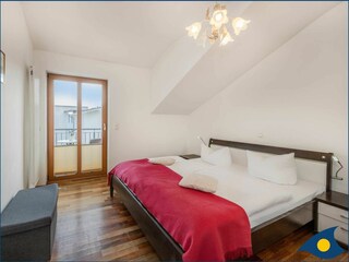 separates Schlafzimmer mit Doppelbett und Balkon