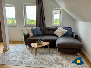 Wohnbereich mit offener Küche und Schlafcouch