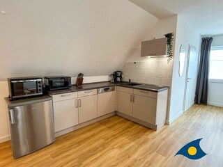 Wohnbereich mit offener Küche und Schlafcouch