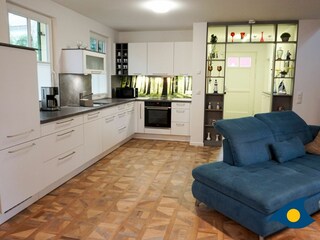 großzügiges Wohnzimmer mit Kamin, Essbereich und offener Küche