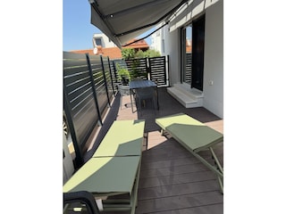 Terrasse mit Sonnenliegen und Sonnenschutz