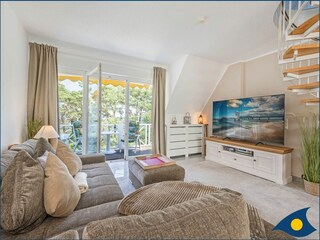 Wohnzimmer mit Esstisch und Zugang zum Balkon