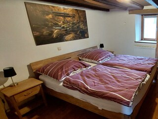 Doppelschlafzimmer mit Steinwand