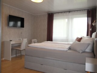 Schlafzimmer mit Smart TV + Schreibtisch