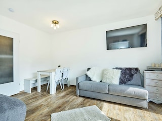 Heller Wohnbereich mit Doppelbett und Couch