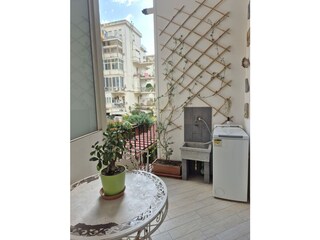 small balcony with washing machine and liberty table