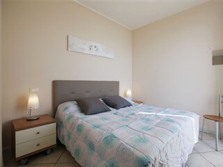 Schlafzimmer mit Doppelbett, Traumseesicht und Ausgang auf den Balkon