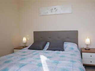 Schlafzimmer mit Doppelbett, Traumseesicht und Ausgang auf den Balkon