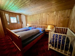 Schlafzimmer mit Doppelbett und Kinderbett
