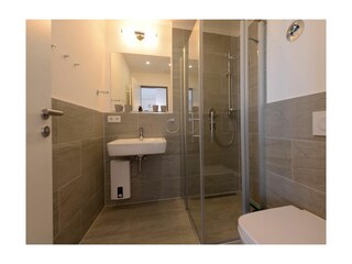 Die Dusche ist bodengleich und per Glaskabine abgetrennt