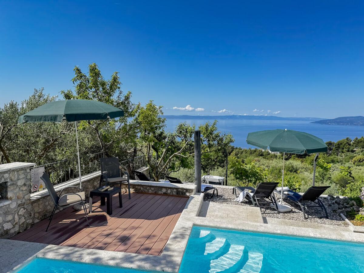 Terrasse am Pool mit Gartenmöbeln und Meerblick