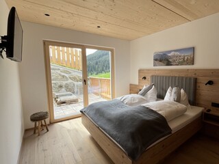 Schlafzimmer mit Austritt auf die seitliche Terrasse