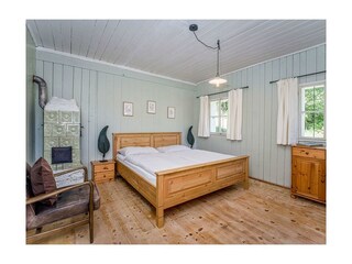 Zimmer mit Kachelofen und Holzbett