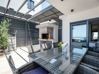 Terrasse mit Grillstelle und Esstisch