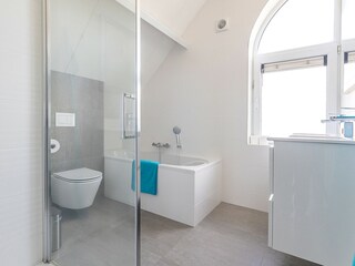 Extended luxury bathroom with separate bathtub and show