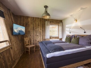 Schlafzimmer mit Badewanne und Fernseher