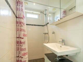 Badezimmer mit Dusche, Waschbecken und Toilette