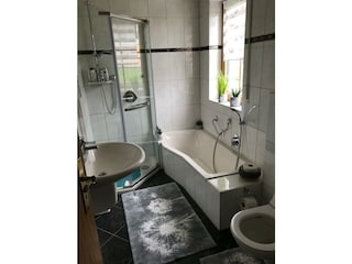 Badezimmer mit Badewanne und Dusche
