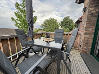 Gemütlicher Balkon mit 4 Stühlen und Sonnenschirm
