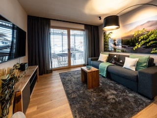 Wohnzimmer mit hochwertigem Schlafsofa und 55" Smart-TV